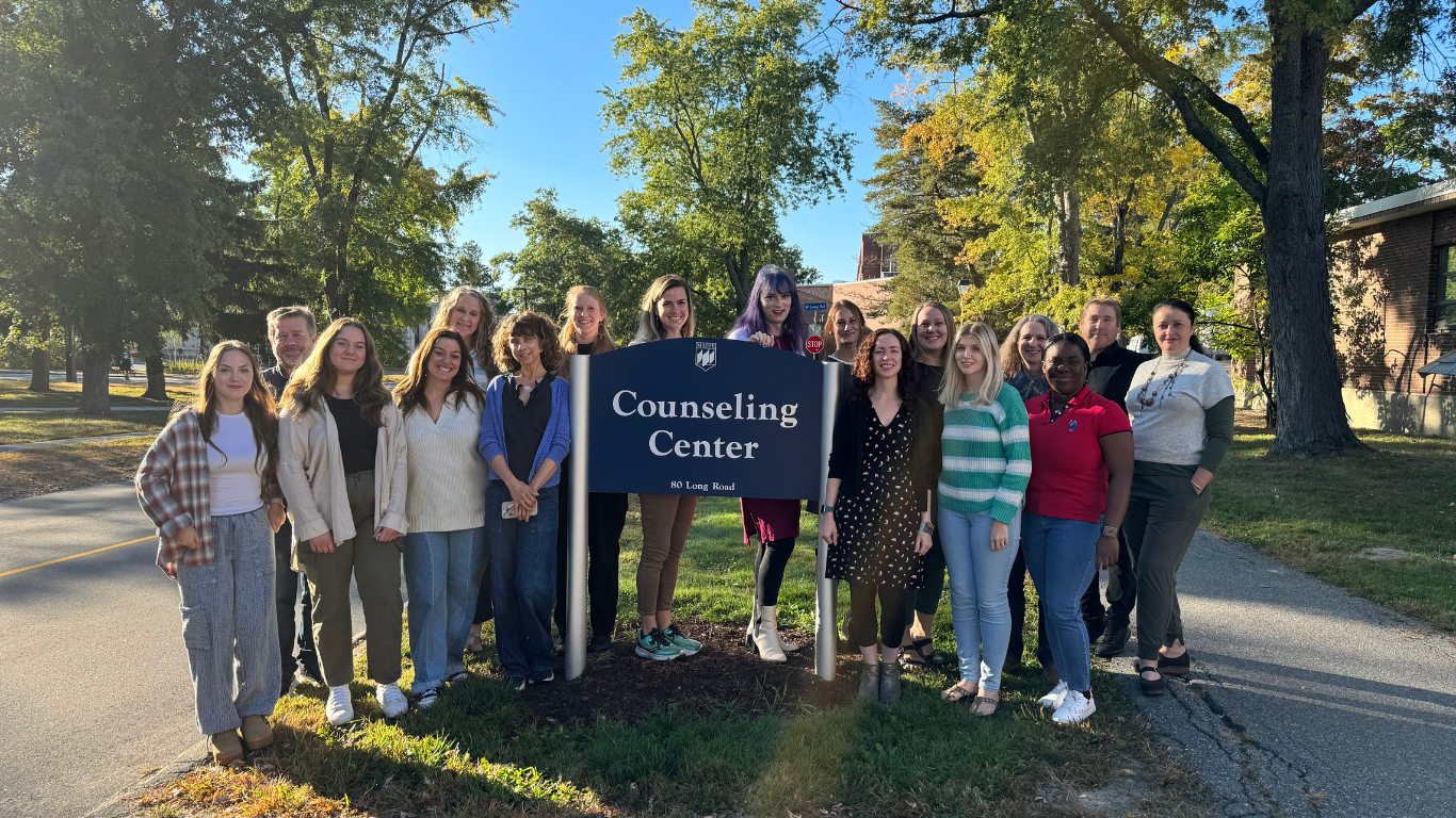 counseling center staff posing in front of the counseling center sign outside the building.